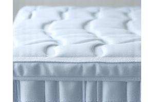 Close-up of a premium cooling mattress with a breathable, textured surface, indicating advanced temperature regulation technology.